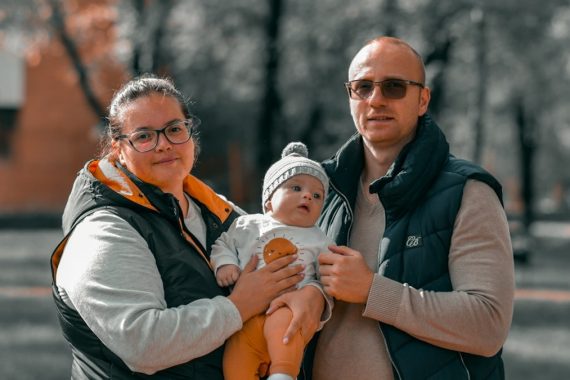 a man and woman holding a baby